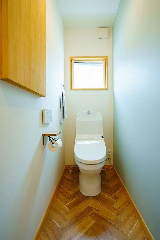【1F　トイレ】<br>ヘリンボーンの床と壁のアクセントクロスで、さわやかな印象に。